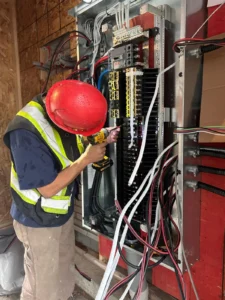 450 Booth Street electrical panel installation with an electrician working on service distribution wiring during construction.