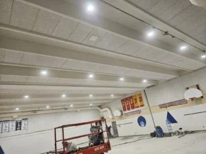 Dr. F.J. MacDonald School gym lighting upgrade showing new LED fixtures installed across the ceiling during renovation.
