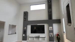 Custom Home in Greely living room with recessed accent lighting, illuminated wall niches, and finished media wall.