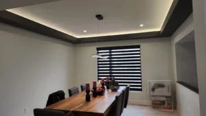 Custom Home in Greely dining room with LED cove lighting, recessed lights, and modern pendant fixture.