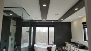 Custom Home in Greely bathroom with recessed ceiling lights, accent lighting, glass shower, and freestanding tub.