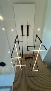 InHarmony Developments custom home with geometric pendant lighting, recessed ceiling lights, and wood feature wall.