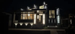 InHarmony Developments custom home exterior at night with landscape lighting, illuminated address numbers, and finished residential electrical work.