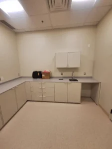 Dental & Plastic Surgery Facility clinical room with LED ceiling lights, cabinetry, sink, receptacles, and finished medical electrical fit up.