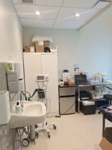 Dental & Plastic Surgery Facility clinical support room with recessed ceiling lights, sink, medical equipment, and finished electrical fit up.