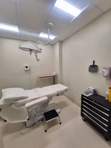 Dental & Plastic Surgery Facility procedure room with LED ceiling lights, surgical task light, treatment chair, and medical equipment power.