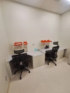 Dental & Plastic Surgery Facility staff work area with desks, task stations, ceiling lighting, and finished medical electrical fit up.