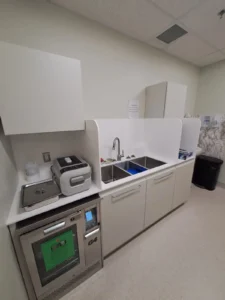 Dental & Plastic Surgery Facility sterilization area with clinical equipment, sink, cabinetry, and finished medical electrical fit up.