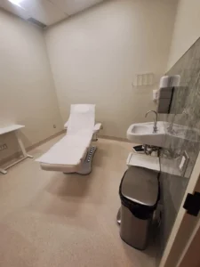 Dental & Plastic Surgery Facility treatment room with LED ceiling lighting, exam chair, sink, and finished medical electrical fit up.