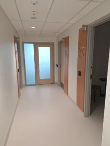 Ottawa Nurse Practitioner-Led Clinic corridor with recessed lighting, fire alarm devices, room controls, and finished electrical upgrades.
