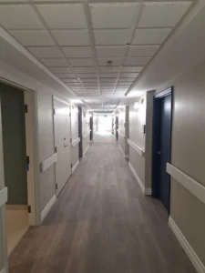 Windsor Park renovation hallway at Old Faulks Home with new wall lighting and updated corridor finishes.