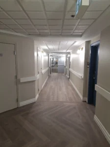 Windsor Park renovation hallway at Old Faulks Home with new wall lighting and upgraded corridor electrical systems.