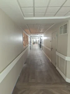 Windsor Park renovation hallway at Old Faulks Home with updated corridor lighting and life safety electrical upgrades.