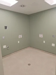 Windsor Park renovation laundry room at Old Faulks Home with ceiling panel lighting, outlets, and utility rough ins.