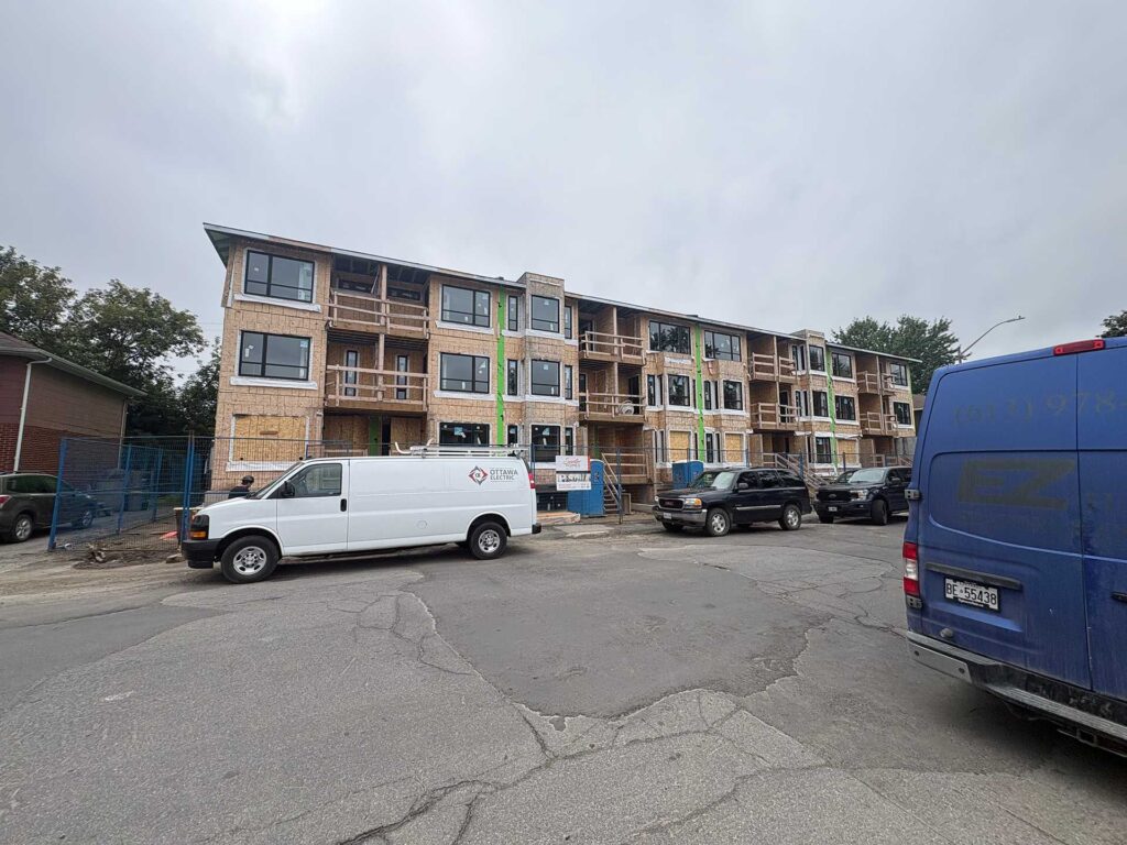 32 unit residential building under construction in Vanier, Ottawa, with an Ottawa Electric service van parked in front.